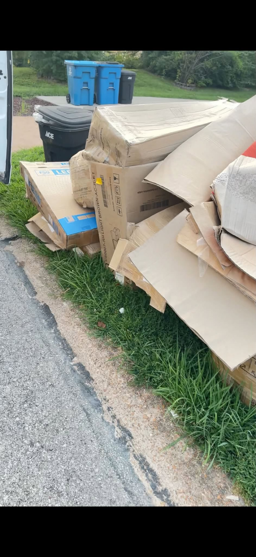 Cardboard and bulk waste piled at the curb for pickup